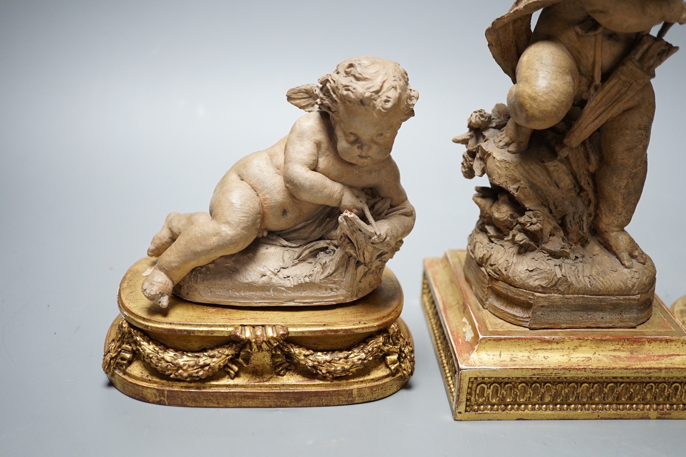 Two 19th century French terracotta cherubs and one other Cupid, after Clodion, all on giltwood stands, tallest 23.5cm